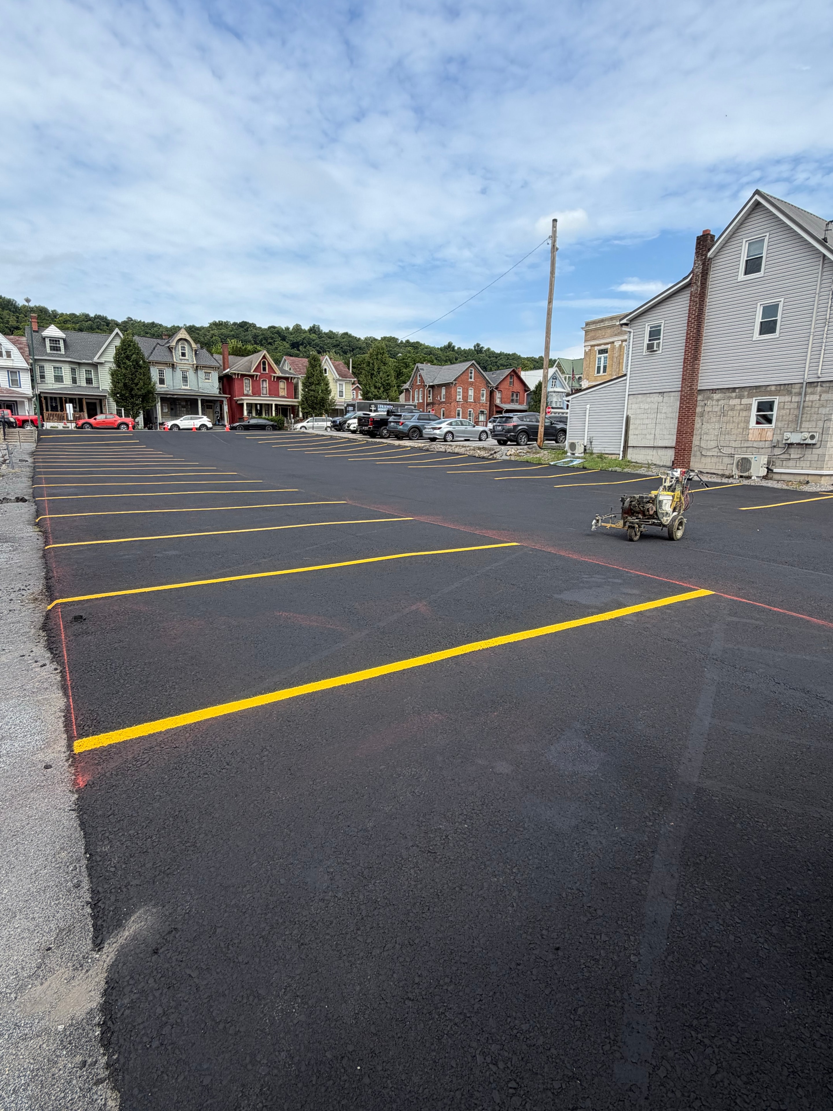 Freshly paved and line-striped town parking lot with yellow markings