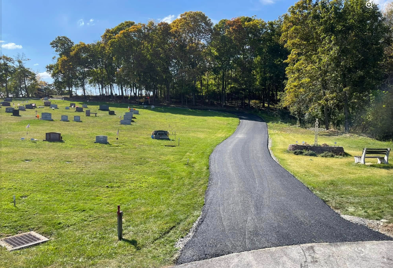 Winding cemetery road freshly paved in autumn