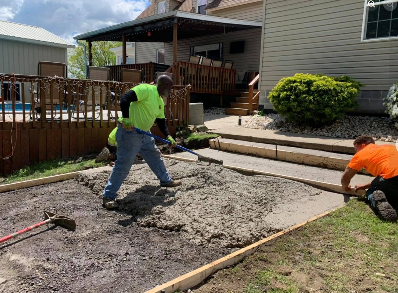 Crew paving split-level home driveway with roller