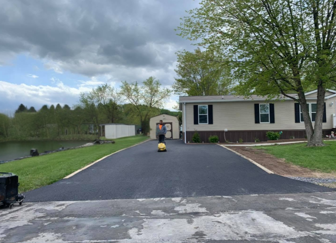 Crew paving long winding driveway in autumn