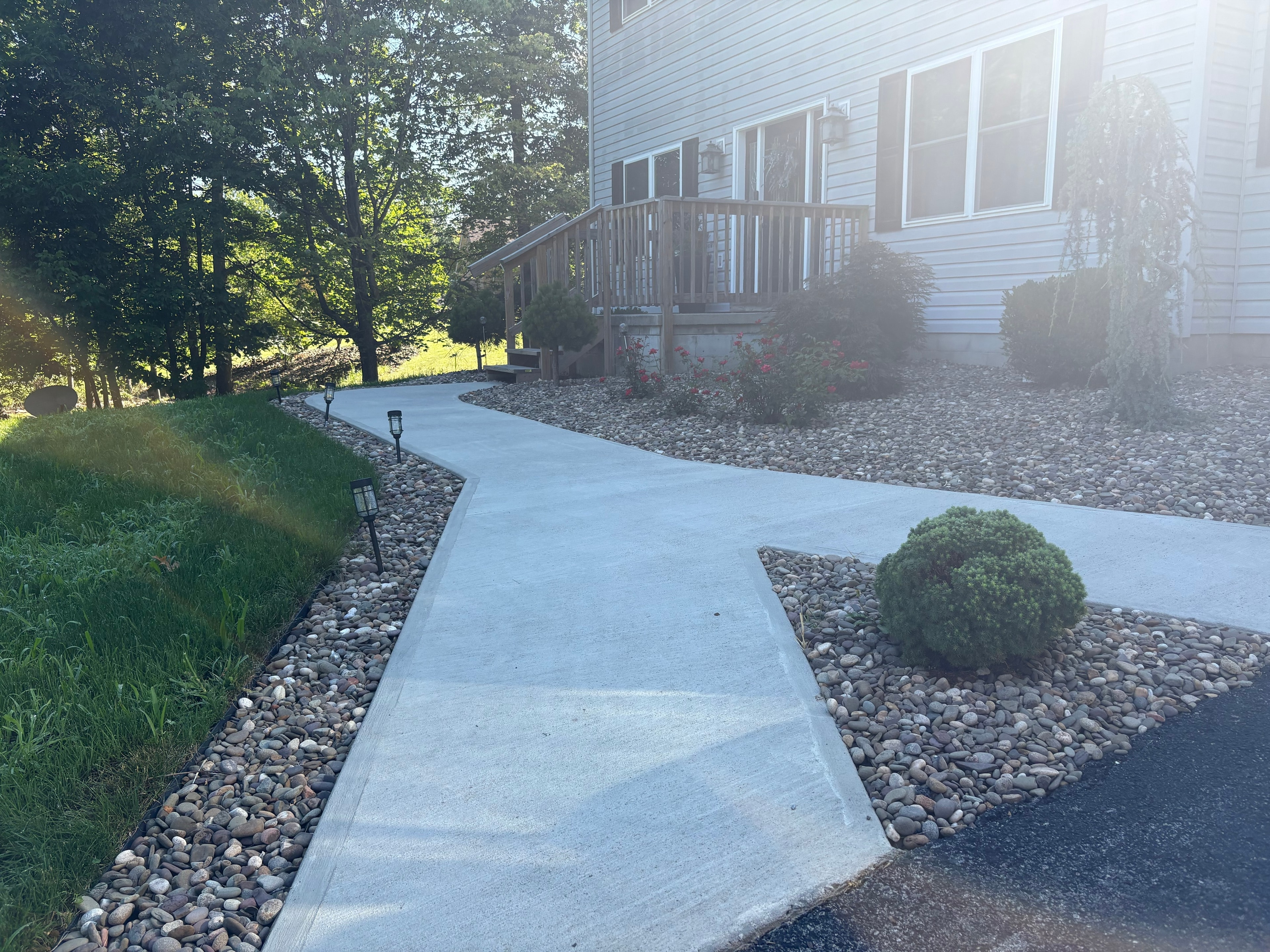 Crew with paver and roller laying residential driveway