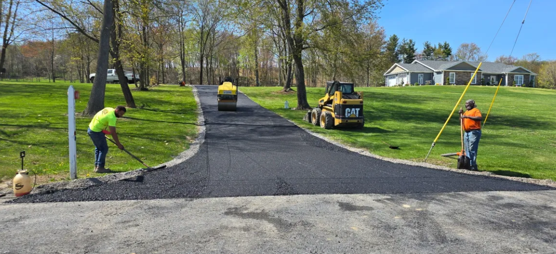 Aloners crew finishing long rural driveway with CAT equipment