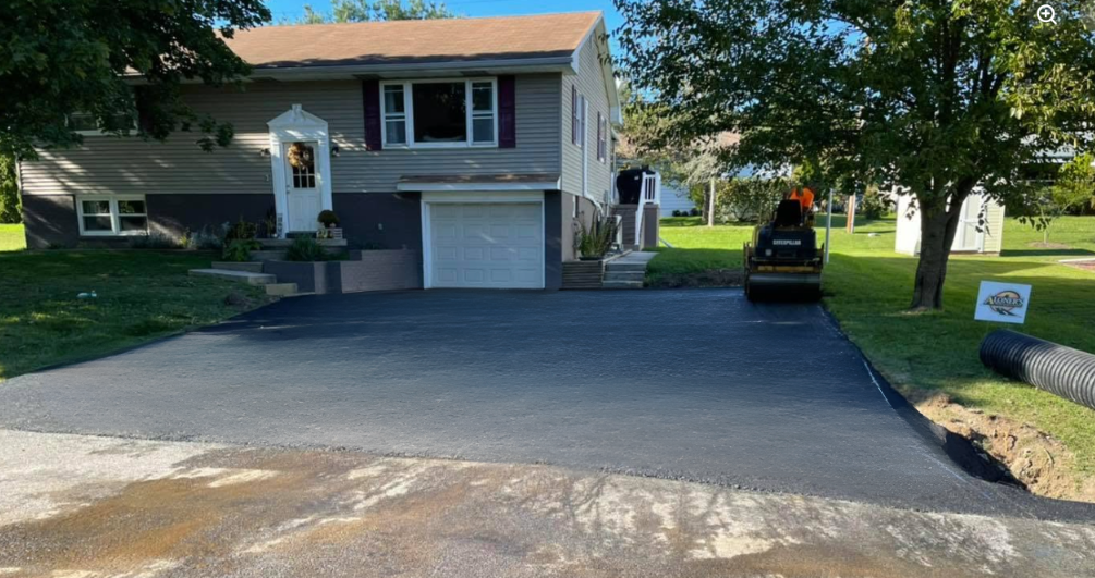 Freshly sealed wide driveway with flower garden