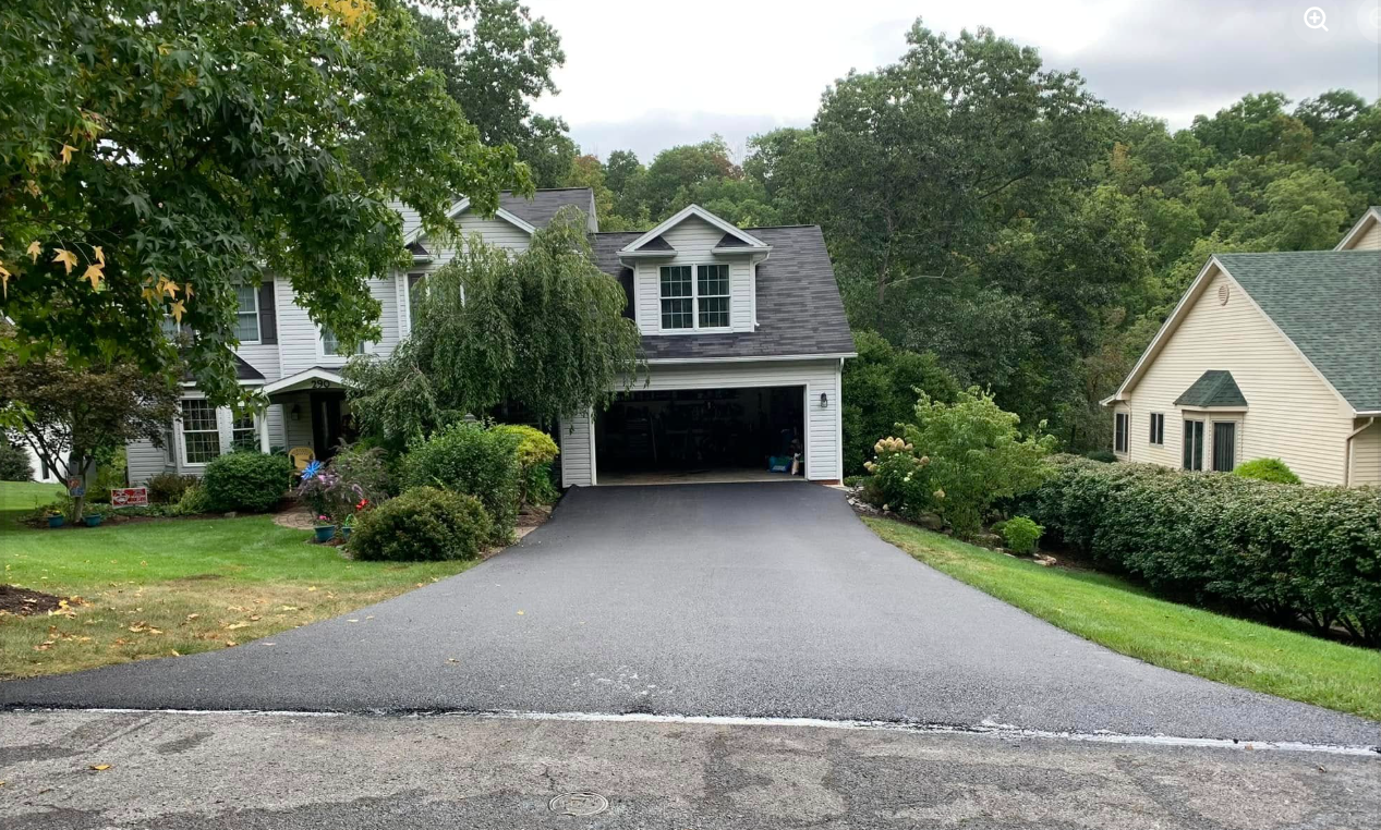Freshly paved driveway at two-story suburban home